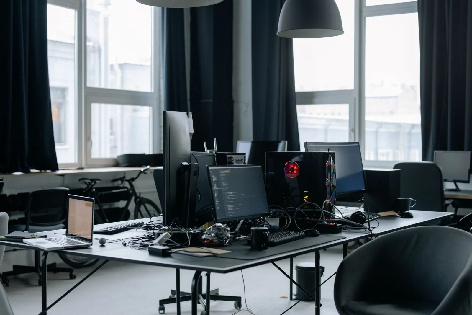 Startup office workstations with monitors and laptops
